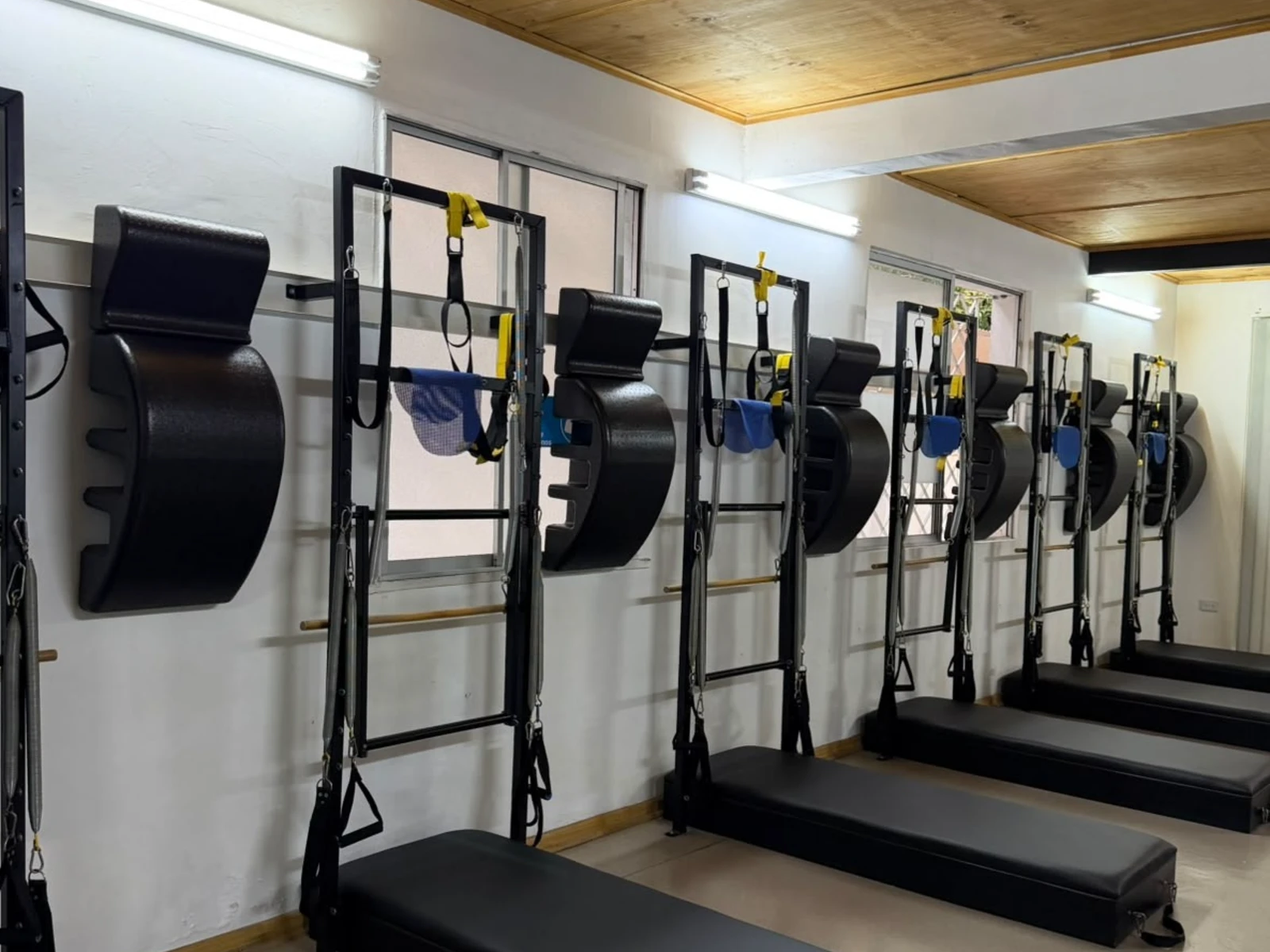 Sala de pilates de Espacio Imagine con los Spine Corrector colgados en soportes impresos en 3D junto a cada torre